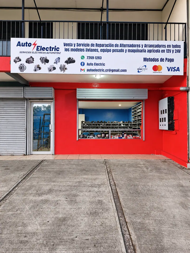 Fachada roja del local de Auto Electric con su rótulo